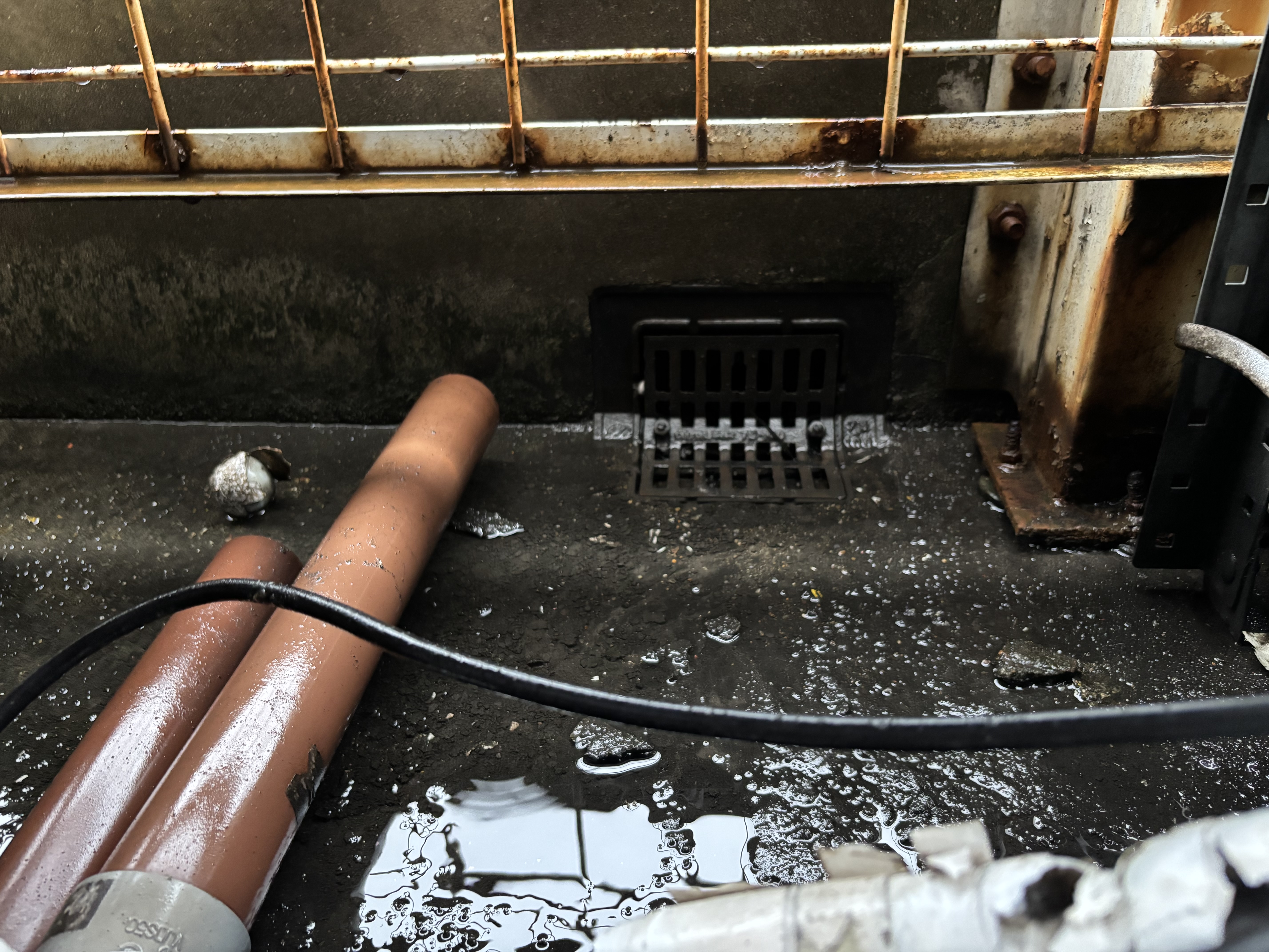 雨漏りの原因となった排水口の泥詰まりと簡易清掃後の比較